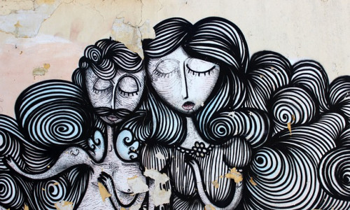 Street-Art-Wandbild eines Mannes und einer Frau mit geschlossenen Augen, erstellt mit wirbelnden schwarzen und weißen Linien auf einer verwitterten Wand.